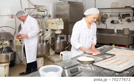 Woman baker forming dough Woman baker forming dough 70277672
