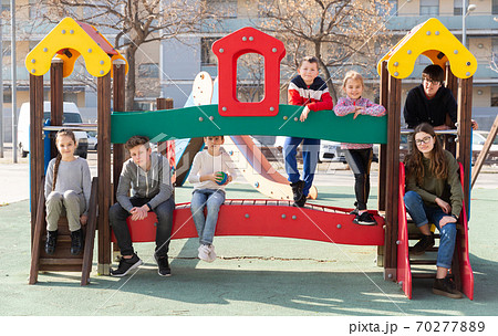 Seven children posing together on jungle gym 70277889