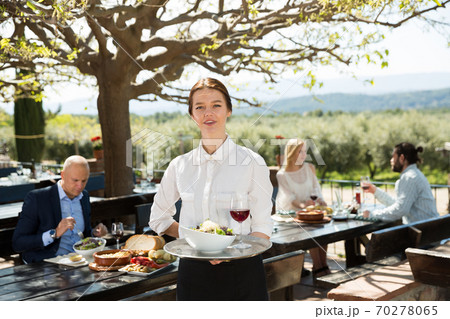 Female owner of country restaurant in open air meeting guests Female owner of country restaurant in open air meeting guests 70278065