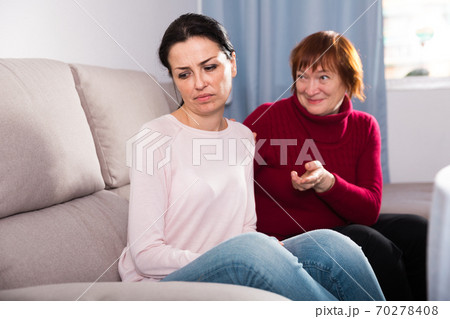 Mature female consoling daughter at sofa after quarrel Mature female consoling daughter at sofa after quarrel 70278408