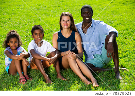 Family sitting on green lawn 70279023