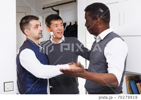 Adult male is welcoming his friends who visit him Adult male is welcoming his friends who visit him 70279919
