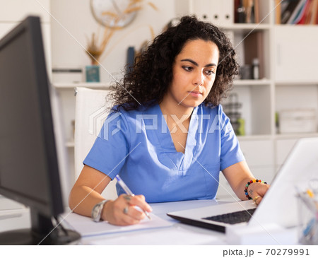 Female doctor working on laptop in office 70279991