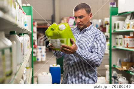 Man holding plastic gallon in hypermarket Man holding plastic gallon in hypermarket 70280249