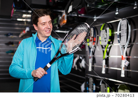 Man choosing new tennis rocket 70280413