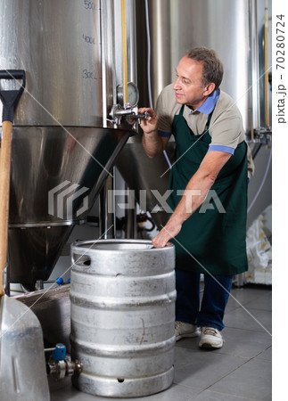 Portrait of brewer who is making beer and controls the process in the brew-house. Portrait of brewer who is making beer and controls the process in the brew-house. 70280724
