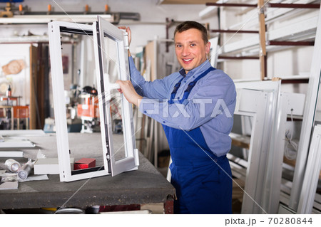 Guy worker is demonstrating the window frame Guy worker is demonstrating the window frame 70280844