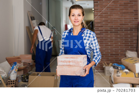 Female worker holding bricks Female worker holding bricks 70281703