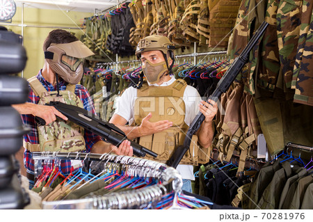 Male customers try on ammunition with weapon Male customers try on ammunition with weapon 70281976