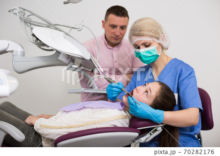 Girl visiting dentistry with father Girl visiting dentistry with father 70282176