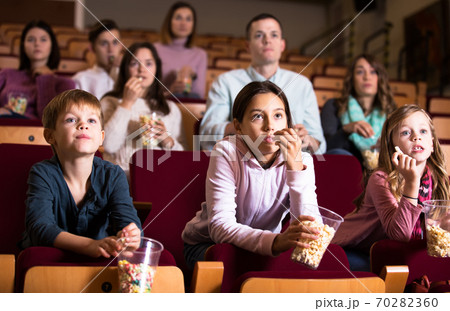 People eating popcorn in cinema People eating popcorn in cinema 70282360