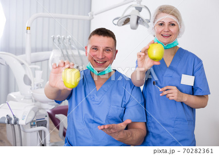 Two smiling dentists with apples Two smiling dentists with apples 70282361