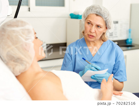 Doctor beautician polls a patient at the clinic 70282516