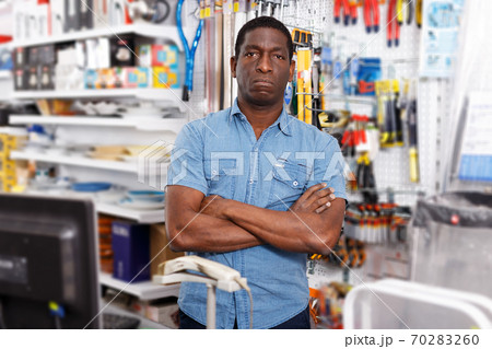 owner of household goods store standing behind counter owner of household goods store standing behind counter 70283260