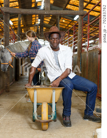 Man and woman delivering oats at stable Man and woman delivering oats at stable 70283762