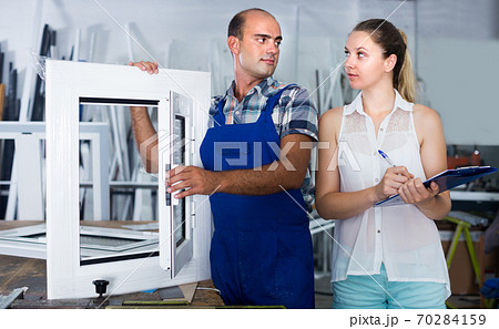Supervisor woman and professional worker controlling quality of finished plastic glazed window Supervisor woman and professional worker controlling quality of finished plastic glazed window 70284159