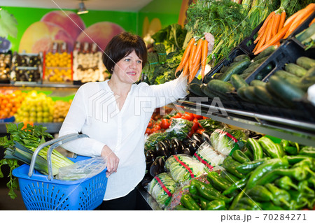 Mature woman buying fresh vegetables Mature woman buying fresh vegetables 70284271