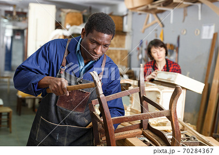 Professional restorer renewing vintage armchair 70284367