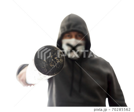 Man in mask and hoodie pokes in face with baseball bat, isolated 70285562