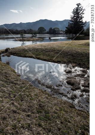 大覚寺門跡、初春の寒空の下に静かに水を湛える大沢池と「平安の遣水」に映る冬雲 70287353