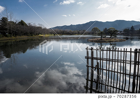 大覚寺門跡、初春の寒空の下に静かに水を湛える大沢池に映る冬雲の写真 