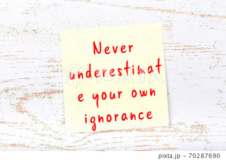 Yellow sticky note on wooden wall with wise quote Yellow sticky note on wooden wall with wise quote 70287690