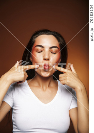 pretty girl happy posing: brunette on brown background, lifestyle people concept 70288154