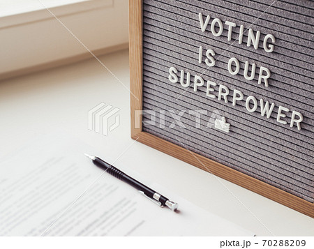 Letter board with phrase Voting is our superpower. Announcement of USA Presidential Election at 3rd November 2020. Call to go to the vote. Paper ballot and pen on window sill. Letter board with phrase Voting is our superpower. Announcement of USA Presidential Election at 3rd November 2020. Call to go to the vote. Paper ballot and pen on window sill. 70288209
