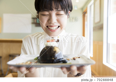 カフェで可愛いケーキを眺める若い女性 女子大生の写真素材