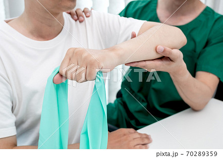 male physiotherapists provide assistance to male patients with elbow injuries to examine patients in rehabilitation centers. Rehabilitation physiotherapy concept 70289359