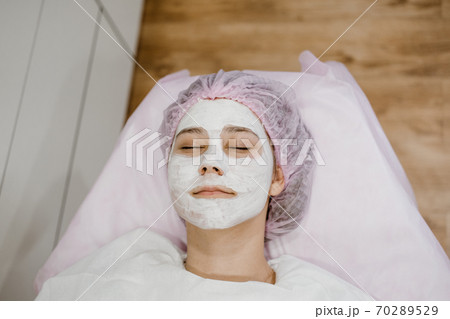 Professional facial skin care routine for teens in beauty salon. Professional Face mask for young adult. Acne Treatment, face peeling mask Professional facial skin care routine for teens in beauty salon. Professional Face mask for young adult. Acne Treatment, face peeling mask 70289529