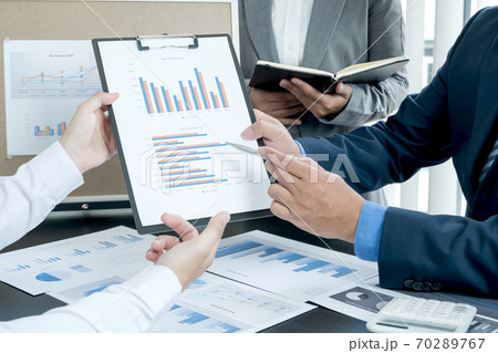 Three business leaders talk about charts, financial graphs showing results are analyzing and calculating planning strategies, business success building processes Three business leaders talk about charts, financial graphs showing results are analyzing and calculating planning strategies, business success building processes 70289767