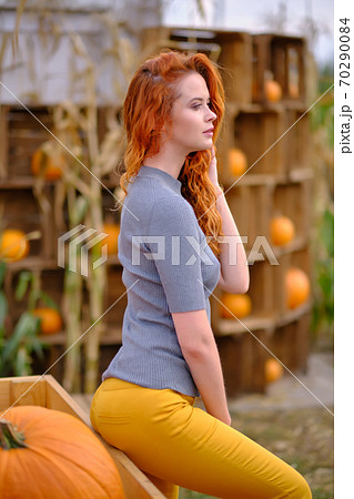 Autumn portrait of a beautiful woman with pumpkins 70290084