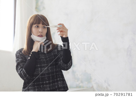 熱を測る　コロナか？インフルエンザか？不安になる女性 70291781