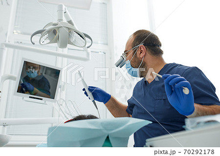 people, medicine, stomatology and health care concept - happy male dentist with woman patient at dental clinic office 70292178