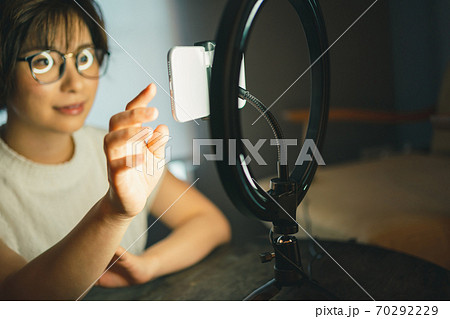 スマホ用リングライトでSNSライブ配信をする女性 70292229