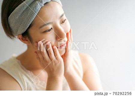 フェイスマッサージをする30代女性 70292256