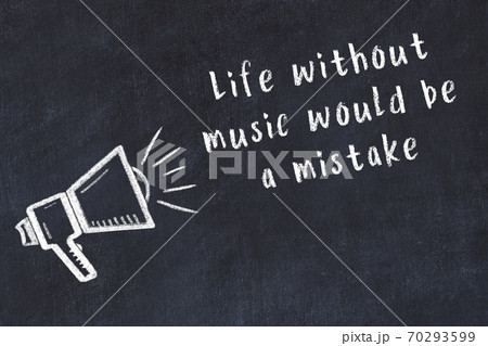 Chalk loudspeaker and wise quote on black desk 70293599