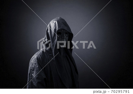 Ghostly figure in hooded cloak in the dark 70295791