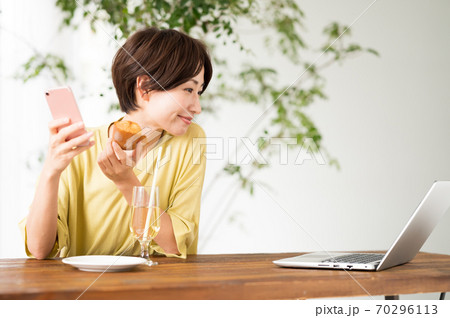 カフェで一息いれながらワーケーション中の女性 70296113