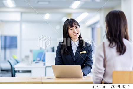 受付にいるスーツの女性に相談するイメージ 受付にいるスーツの女性に相談するイメージ 70296814