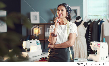 Thoughtful tailor standing sewing workshop Thoughtful tailor standing sewing workshop 70297612
