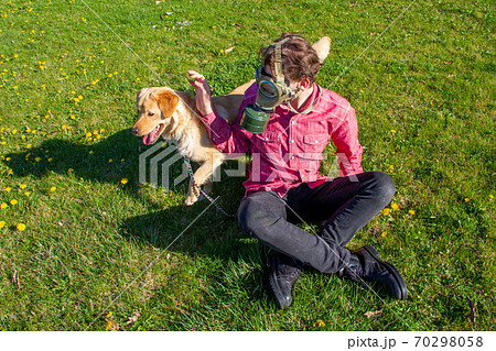 boy wearing old style virus mask with his dog playing at garden boy wearing old style virus mask with his dog playing at garden 70298058