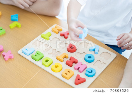 幼児教室 英語学習 アルファベットのブロックを型にはめる子供の手元 幼児教室 英語学習 アルファベットのブロックを型にはめる子供の手元 70303526