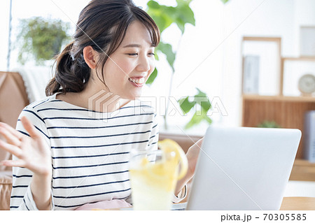 ノートパソコンでオンライン飲み会をする若い女性 70305585
