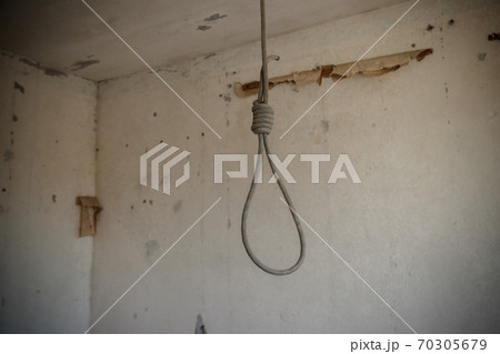 Deadly loop hanging from the ceiling in abandoned apartment. Concept of suicide, despair 70305679