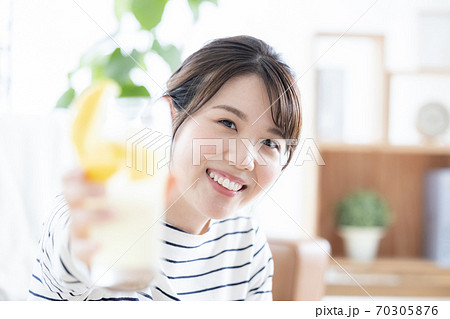 女性のポートレート カメラ目線で乾杯する女性の写真素材