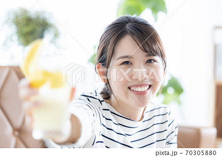 女性のポートレート カメラ目線で乾杯する女性の写真素材
