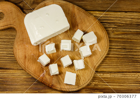 Feta cheese on cutting board on a wooden table. Top view 70306377