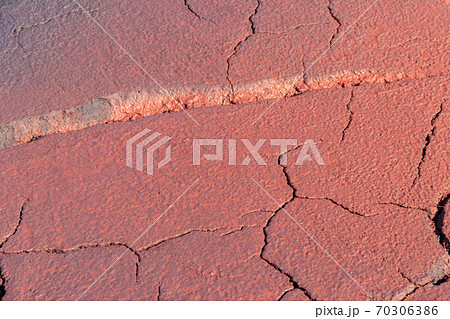 Texture of red wet ground polluted with iron ore waste 70306386